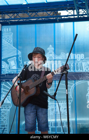 Royal Mile, Mercat Stadium, Edinburgh, Schottland, Großbritannien. 3. August 2019. Edinburgh Fringe, eine selbstbewusste 12-jährige Stuart Veitch von Aberdeen führt Gesang und E-Gitarre zu einem dankbaren Publikum. Stockfoto