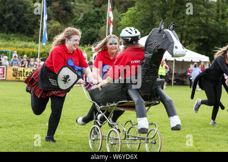 Dundonald, UK. 03. Juli 2019. Die Ayrshire Dorf Dundonald feierte den 30. Jahrestag der Holding Highland Games durch Wettbewerbe von Crazy pram Racing und juvenile Tauziehen neben den traditionellen Wettbewerben der werfen der Caber, wirft den Hammer und die Keppoch Stein heben. Das siegerteam im Kinderwagen race TEAM BRAVEHEART mit Mitgliedern Alex Galloway, REBECCA McNEIL und MORGAN McCORMICK alle von Dundonald. Stockfoto