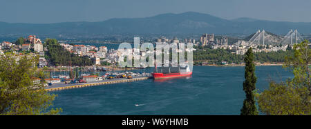 Panoramablick über Hafen City. Stadtbild Hintergrund. Hafenstadt mit Bergen im Hintergrund. Fähre, Schiff in der Nähe der Stadt. Die schöne Natur der europäischen Stadt. Europa reisen. Red Boot im Hafen Stockfoto