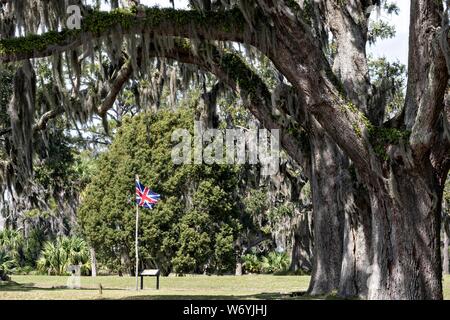 Spanisch moss deckt live Eichen über eine Britische Flagge am Fort Frederica National Monument, der ursprünglichen kolonialen Siedlung in St. Simons Island, Georgia hängen. Fort Frederica wurde durch Georgien Gründer James Oglethorpe 1736 gegründet als Bollwerk gegen die spanischen Siedlungen in Florida zu dienen, Stockfoto