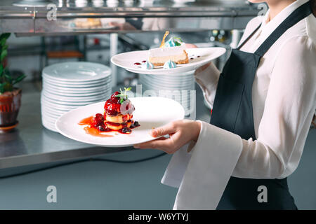 Kellner serviert in motion im Restaurant. Der Kellner trägt Gerichte. Stockfoto