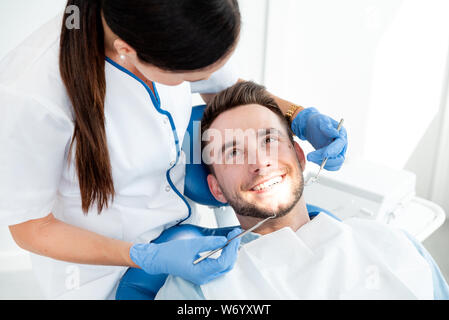 Mann, der Zähne Zahnärzte untersucht. Übersicht von Karies Vorbeugung Stockfoto