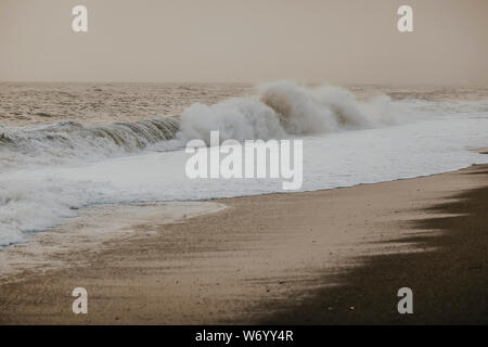 Wogende Wellen schlagen die Küste bei stürmischem Wetter Stockfoto