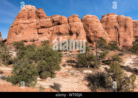 Eine große monolithische Wand ergänzt die Schönheit der Wüste. In der dramatischen Chesler Park im Needles District - Canyonlands National entfernt Stockfoto