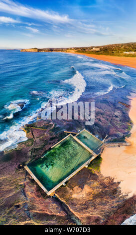 MOna Vale Strand und Rock Pool an der Spitze der Sandstrand auf Sydney Northern Beaches bei Sonnenaufgang mit Schwimmern und Surfern schwimmen und Reiten die Stockfoto