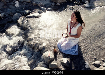 Foto von Elena Ray. Lichtarbeiter Frau mit Kristall Angebot im Wasser von einem wilden Fluss. Stockfoto