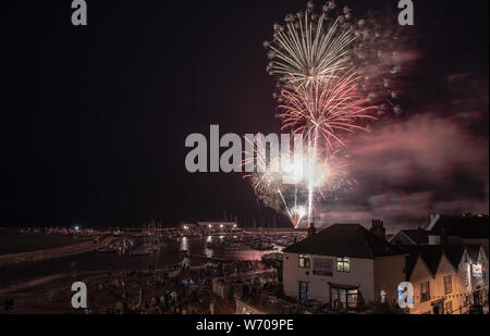 Lyme Regis, Dorset, Großbritannien. August 2019. UK Wetter: Menschenmassen versammeln sich an einem warmen Sommerabend die jährlichen August Feuerwerk im Cobb Hafen Lyme Regis zu beobachten. Die Charity Veranstaltung findet jedes Jahr im Rahmen der Regatta, Karneval und Rettungsboot Woche und ist von den Einheimischen und Besucher der Stadt mit vielen kehren Jahr für Jahr besucht. Credit: Celia McMahon/Alamy Leben Nachrichten. Stockfoto