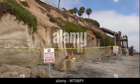 Warnzeichen und Vorsicht Band Menschen aus instabilen Klippen halten am Grandview Strand in Encinitas, Ca-Seite von einem tödlichen Bluff zusammenbrechen. Stockfoto