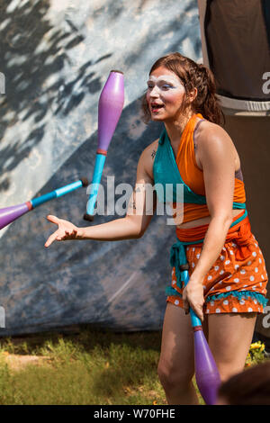 Sandy Springs, GA, USA - 22. September 2018: Ein weiblicher Jongleur wirft jonglieren Stifte in die Luft als Sie Gönner an den sandigen Frühlingsfest unterhält. Stockfoto