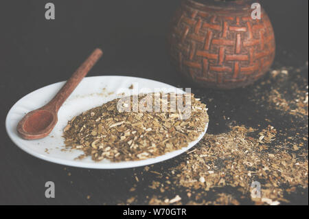 Künstlerische gewaschen Foto des Yerba mate Infusion, typische aus Argentinien, in eine weiße Platte, über einen dunklen Hintergrund Stockfoto