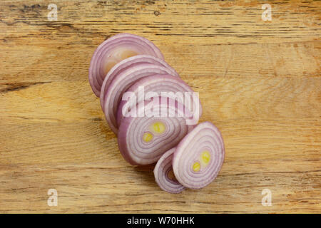 Nahaufnahme der Schichten von frischen, rohen Schalotte auf Holz Schneidebrett Stockfoto