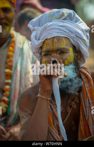 Porträt eines sadhu genießen Rauch beim Holi Feiern im Mathura, Uttarpradesh, Indien, Asien Stockfoto