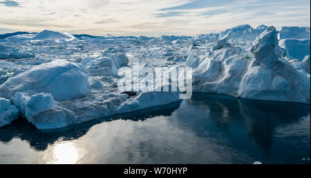 Antenne drone Bild des Eisbergs und Eis von Gletscher in der Arktis Natur Landschaft auf Grönland. Luftbild Drohne Foto von Eisbergen in Ilulissat Eisfjord. Durch den Klimawandel und die globale Erwärmung betroffen. Stockfoto