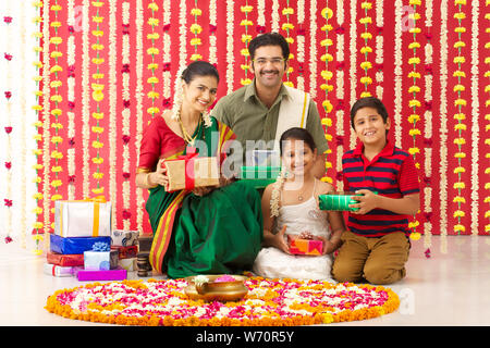 Südindische Familie hält Geschenkboxen und lächelt Stockfoto