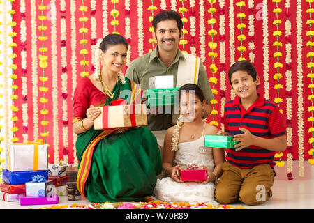 Südindische Familie hält Geschenkboxen und lächelt Stockfoto