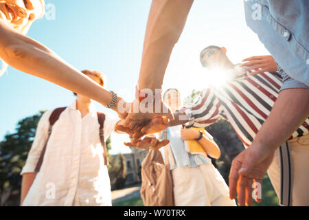 Freundlich groupmates die Hände zusammen, die ausserhalb der Universität. Stockfoto