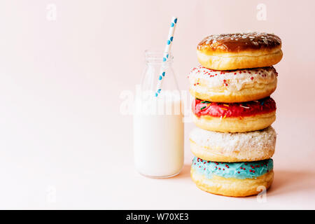 Turm von Donuts und Milch in der Flasche Stockfoto