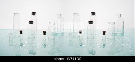 Wenige transparente Flaschen, Wasser spritzt. Leere Glasflaschen Stockfoto