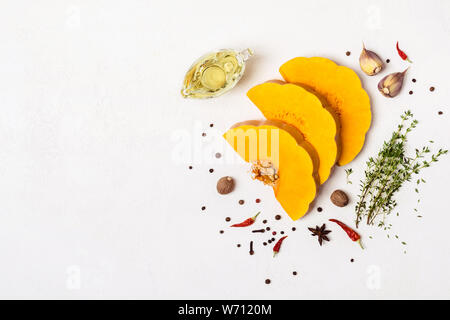 Der Rohstoff Bio Kürbis mit Gewürzen und Olivenöl in Scheiben geschnitten. Für Text oder ein Rezept. Stockfoto
