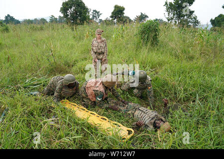 Auf 0001 Montag, 5. August Hauptgefreiter Lyndsey Jenkins, 28, eine spezialisierte Infanterie bekämpfen medizinischer Techniker von Whitley Bay, Newcastle verhangen, hilft dem ugandischen Soldaten in Singo, Uganda. Stockfoto