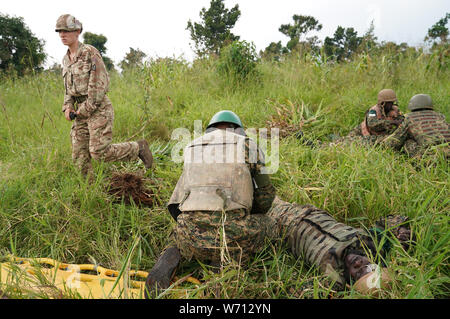 Auf 0001 Montag, 5. August Hauptgefreiter Lyndsey Jenkins, 28, eine spezialisierte Infanterie bekämpfen medizinischer Techniker von Whitley Bay, Newcastle verhangen, hilft dem ugandischen Soldaten in Singo, Uganda. Stockfoto