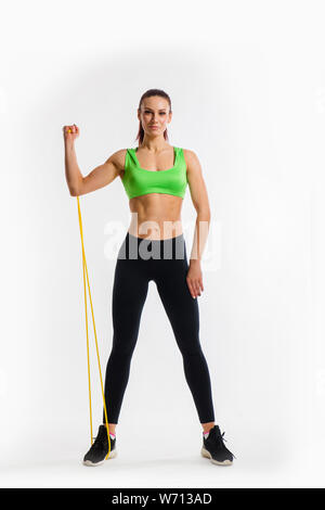 Fitness-Mädchen führt Übungen mit Widerstand Band. Stärke und Motivation Stockfoto