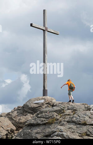 Junge mit minimalistische Schuhe das Erreichen des Gipfels Kreuz, Hauptgipfel, Großer Arber, Bayerischer Wald, Bayern, Deutschland Stockfoto