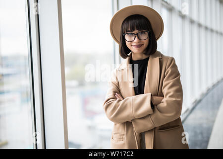 Attraktive junge geschäftsfrau Brille nachdenklich über office Windows starrte auf die Skyline der Stadt. Stockfoto