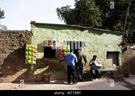 Indische Leute Verkauf und Nahrung und Produkt von lokalen Lebensmittelgeschäft kaufen und Sitzen lesen Zeitung neben Straße in Morgen Zeit in Delhi City am 24. März 2019 Stockfoto