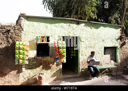 Indische Leute Verkauf und Nahrung und Produkt von lokalen Lebensmittelgeschäft kaufen und Sitzen lesen Zeitung neben Straße in Morgen Zeit in Delhi City am 24. März 2019 Stockfoto