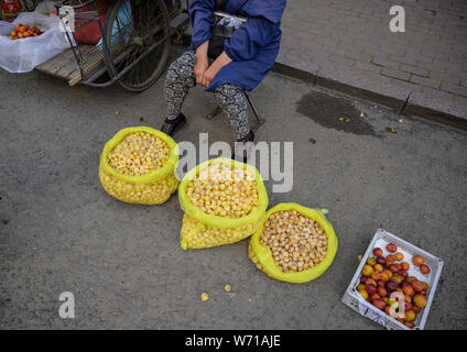 MISHAN, CHINA - Juli 28, 2019: Unbekannter Menschen vor Ort kaufen und verkaufen Produkte auf der Straße in Mishan. Mishan ist eine Stadt in der Stockfoto