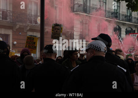 London, Großbritannien. 3. August 2019. Antifa Unterstützer, eine militante Linke Gruppe, ignorieren sie die strengen Auflagen, die von der Polizei verhängt und haben von ihren festen Platz gebrochen Protest zu begegnen und die rechten Flügel frei Tommy Robinson Rallye in der Nähe von Oxford Circus für eine mögliche gewalttätige Konfrontation Ansatz. Credit: Joe Kuis/Alamy Nachrichten Stockfoto