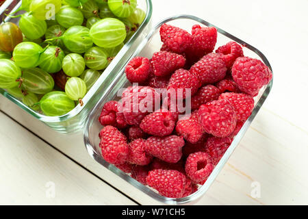 Verschiedene Sommer Beeren rote Johannisbeeren, Stachelbeeren, Himbeeren in Glas Fächer. nach Typ sortiert. superfoods aus dem Garten Stockfoto