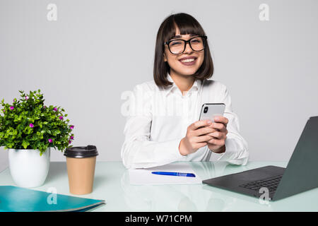 Frau Hand verwendet ein Mobiltelefon und arbeitet in einem Laptop in den Büros. Stockfoto