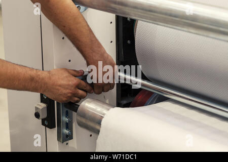 Arbeitnehmer stellt die Maschine zur Herstellung von Papier in Rollen Stockfoto