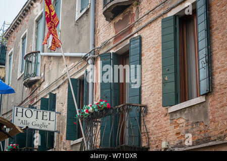 Das Hotel Alle Guglie in Venedig, Italien zeigt Zeichen seines Alters im Mauerwerk und Fensterläden. Stockfoto