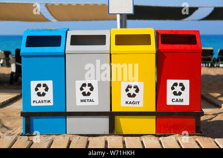 Tankcontainer in verschiedenen Farben für die getrennte Sammlung von Abfällen und Müll auf dem Meer Strand. Stockfoto