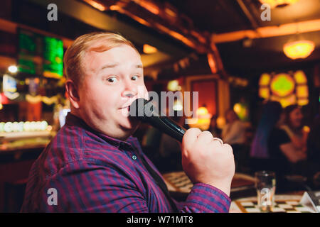 Charmante junge Mann wirkt am Abend Konzert in einem Anzug im Licht der Scheinwerfer. Stockfoto