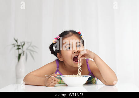 Indische Mädchen essen Nudeln Stockfoto