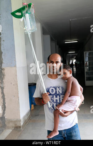 Dhaka, Bangladesch - August 04, 2019: Der Vater kuscheln einem fünf Jahre alten Dengue-fieber-Patienten in den Räumlichkeiten der Heiligen Familie Roten Halbmond medizinische Hochschule Hos Stockfoto