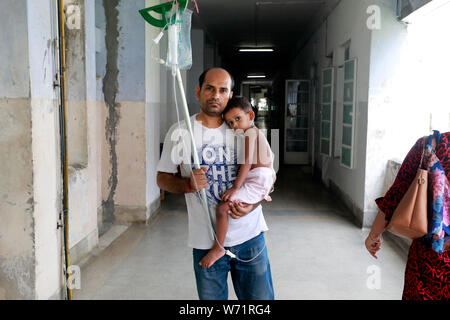 Dhaka, Bangladesch - August 04, 2019: Der Vater kuscheln einem fünf Jahre alten Dengue-fieber-Patienten in den Räumlichkeiten der Heiligen Familie Roten Halbmond medizinische Hochschule Hos Stockfoto