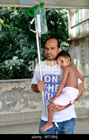 Dhaka, Bangladesch - August 04, 2019: Der Vater kuscheln einem fünf Jahre alten Dengue-fieber-Patienten in den Räumlichkeiten der Heiligen Familie Roten Halbmond medizinische Hochschule Hos Stockfoto