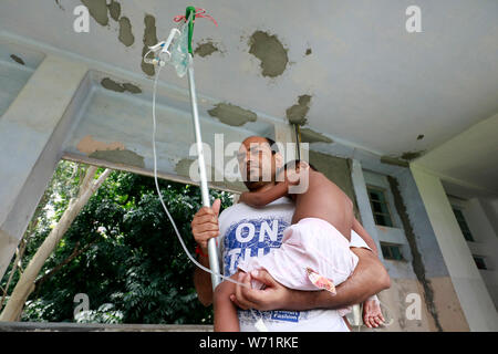 Dhaka, Bangladesch - August 04, 2019: Der Vater kuscheln einem fünf Jahre alten Dengue-fieber-Patienten in den Räumlichkeiten der Heiligen Familie Roten Halbmond medizinische Hochschule Hos Stockfoto