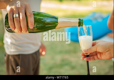 Champagner in ein Glas gießen Stockfoto