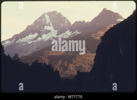 Ein Sonnenuntergang Blick nach Süden durch das SÜDPORTAL VON KEYSTONE CANYON JPEAK 5079. Die Richardson Highway SICHTBAR IST RECHTS UNTEN. Nachdem parallel zu den Canyon entlang einer Bank, auf der östlichen (linken) Seite, DIE PIPELINE AUF DIE EBENE DER LOWE FLUSS UND LAUFEN IN RICHTUNG WESTEN VALDEZ ENTLANG DER UNTEREN sonnenbeschienenen Hängen IN DER MITTE DES BILDES WERDEN. 1,6 km 768-772, ALASKA PIPELINE ROUTE Stockfoto