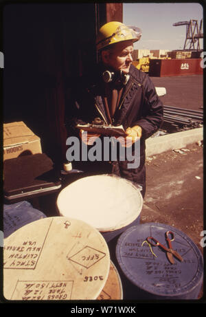 Eine Behörde für Umweltschutz PESTIZIDE INSPECTOR prüft Behältnisse in den Docks am Hafen von Newark, NEW JERSEY PROBEN NIMMT ER AUF EINE EPA-Labor für die Analyse. Stockfoto