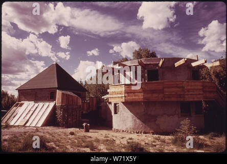 Architekt UND EXPERIMENTELLEN HOUSE BUILDER MICHAEL REYNOLDS LEBT IN DIESER STRUKTUR, ist ein Kompendium von seinen Experimenten IM FELD, in der Nähe von Taos, New Mexico. Der linke Teil der Struktur, der mit dem PYRAMIDENFÖRMIGEN DACH WURDE MIT LEEREN STAHL BIER- UND LIMONADENDOSEN. Die schräge Wand AN DER BASIS ist eine solare Wärme Sammler. REYNOLDS hat ganze Häuser von den Dosen, und Berichte können so viel wie 20 % % % % % % % % günstiger als herkömmliche Gehäuse werden Stockfoto