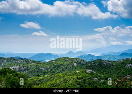 Montenegro, grünen hügeligen Natur Landschaft Baum bedeckte Berge und Hügel rund um skutarisee Wasser unter blauem Himmel im Sommer Stockfoto