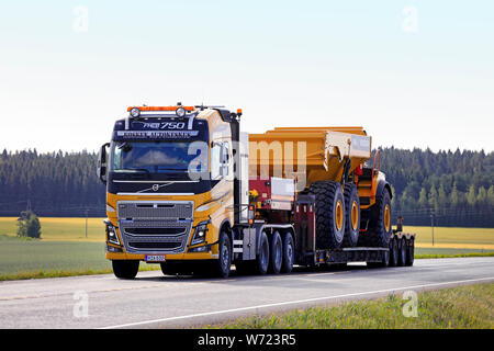 Jokioinen, Finnland. Juli 26, 2019. Gelbe Volvo FH 16 Auflieger von Kosken Autokeskus hols Volvo A 45 G Full Suspension Transportunternehmer auf der Autobahn artikuliert. Stockfoto