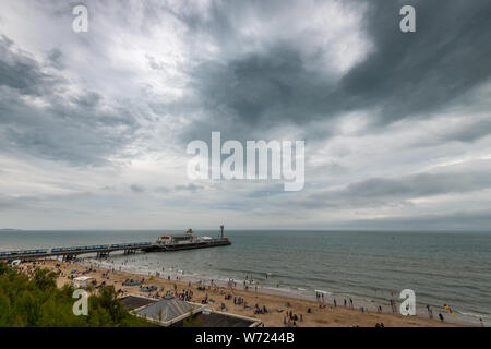 Bournemouth, UK. 4. August 2019. Trübes Wetter mit stürmischen Himmel nicht die Massen von Menschen Bourneomuth genießen Strand und Schwimmen im Meer abhalten. Quelle: Thomas Faull/Alamy leben Nachrichten Stockfoto